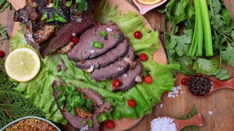 Cooked elk meat laid out across a bed of vegetables