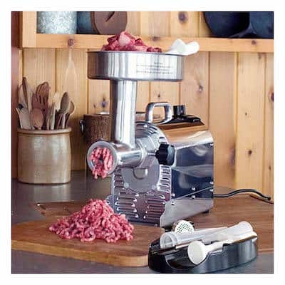 A meat grinder pushing out venison onto a wooden countertop