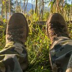 View of an elk hunter's legs with his boots kicked up while resting in a field