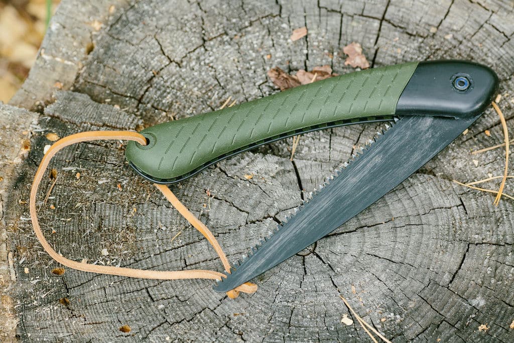 Bahco Laplander folding bone saw with slight wear on a tree stump
