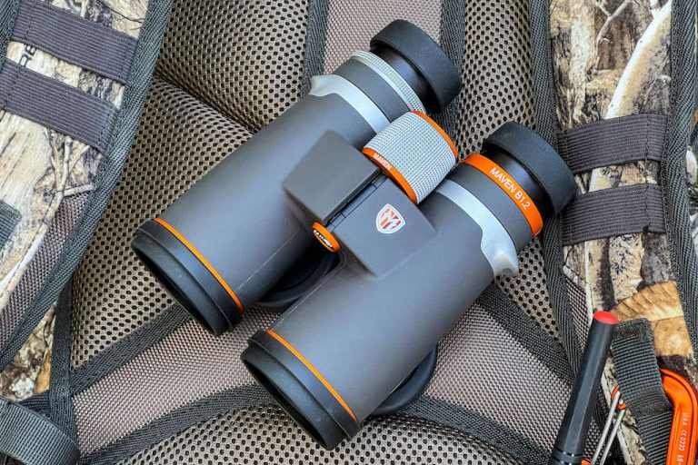 Pair of Maven B1.2 10x42 binoculars sitting on top of a camo hunting backpack