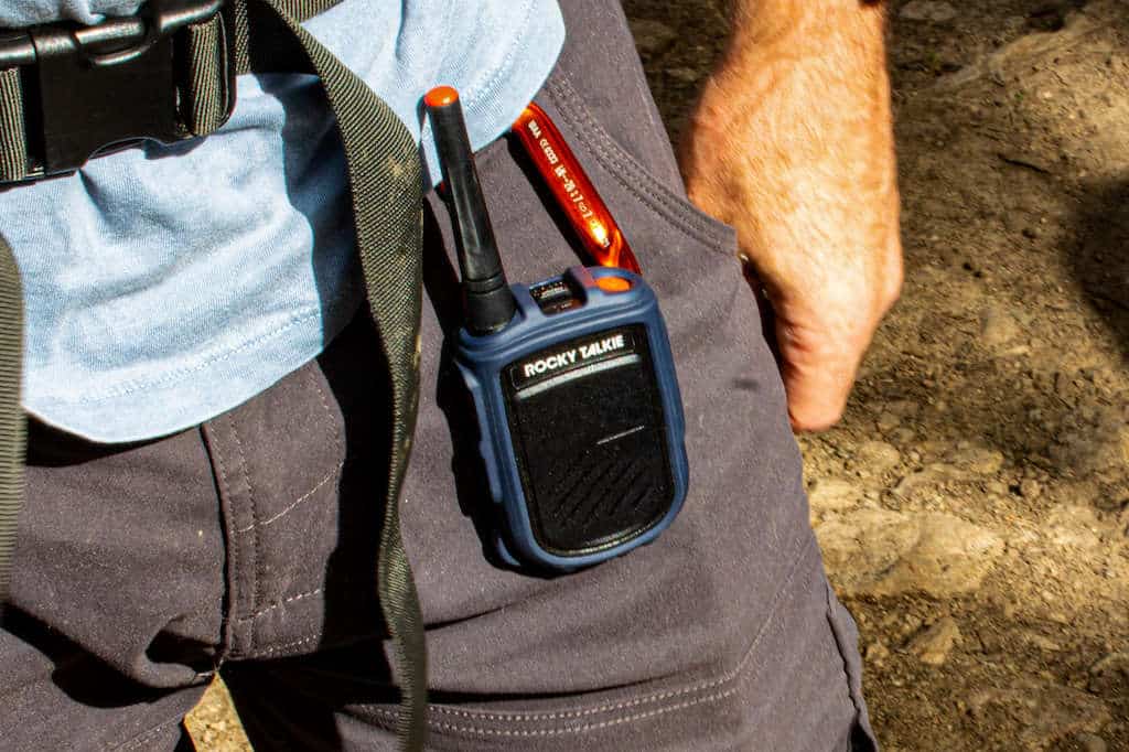 Hiker wearing a two-way communication device on his belt loop on a backcountry trail