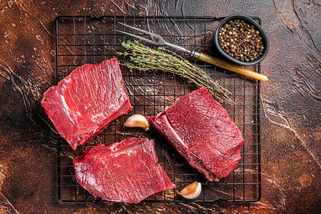 Elk meat (venison) on a cutting board with a hunting knife
