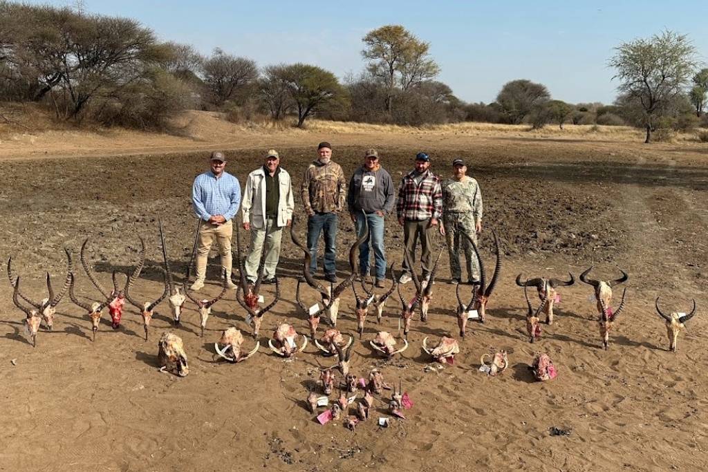 Six Hunters Standing In Front Of The Horns Of Several Dozen Animals That Were Harvested On Their Hunting Trip
