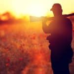 Ethical hunter with a gun resting on his shoulder at sunset
