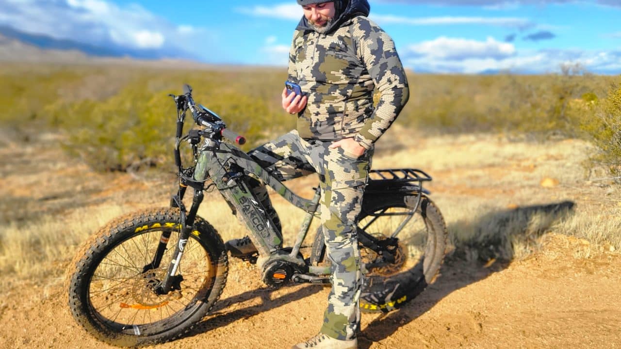 bakcou mule eBike with a hunter checking the map on his phone wearing kuiu camo