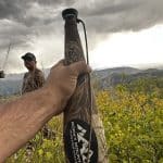 Rocky Mountain Bully Bull Extreme elk bugle tube resting across a hunter's leg as a storm builds over the Colorado high country during archery elk season