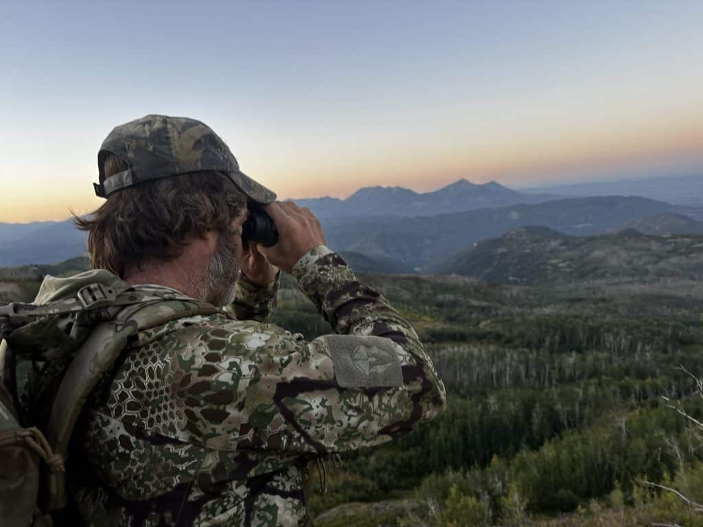Bowhunter glassing a Colorado basin at sunrise with Vortex Fury HD 5000 rangefinding binoculars